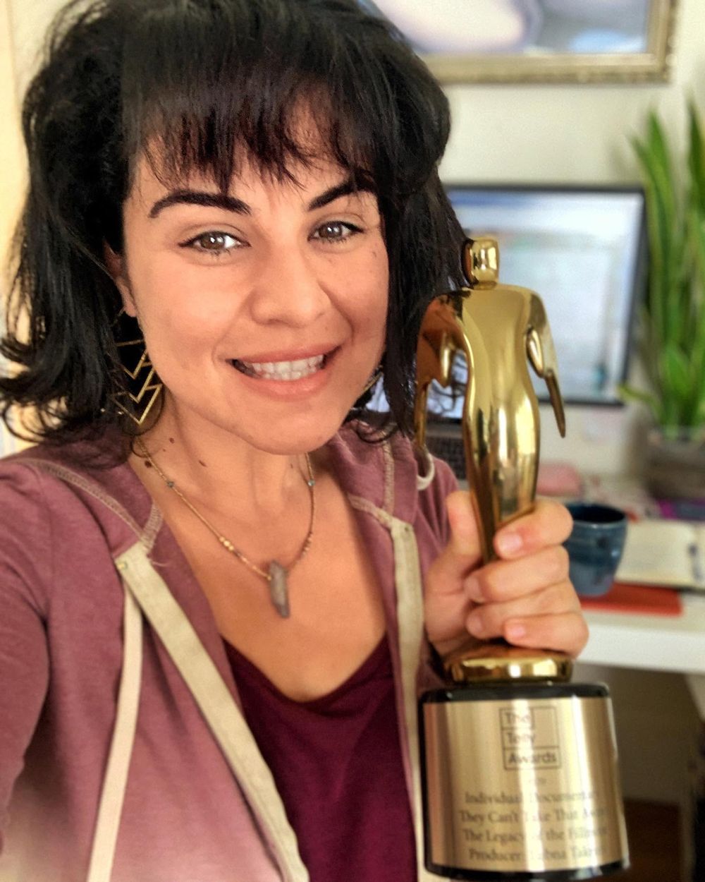 Lubna holding a Gold Telly Award